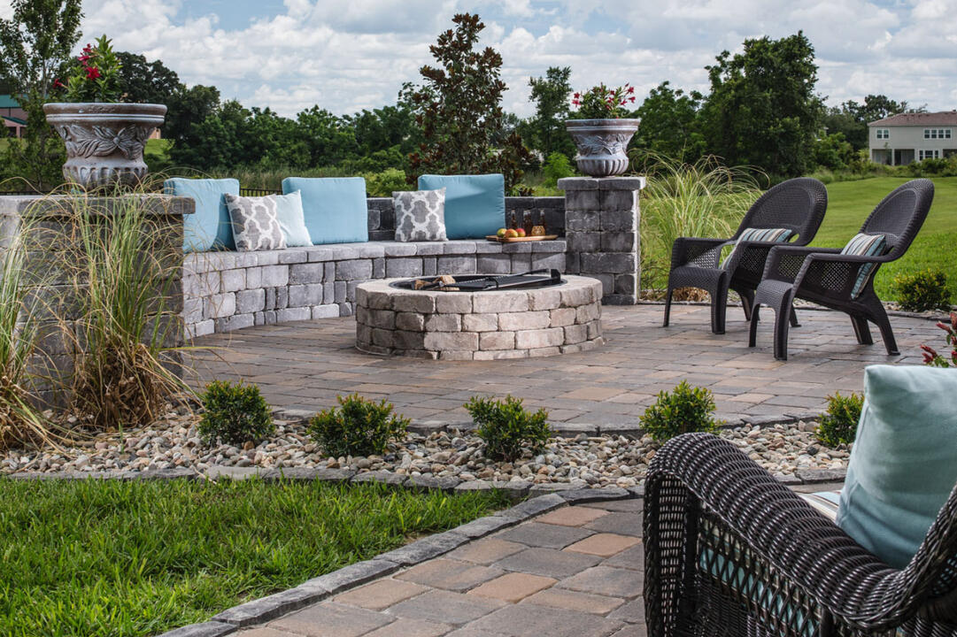 Half-moon Diamond Pro sitting wall with a fire pit on a round paver patio in Brookfield/Waukesha. Designed for outdoor comfort, style, and durability.