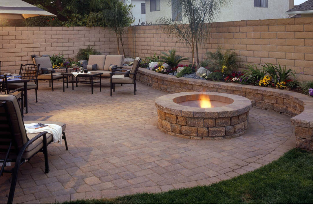 Brookfield, WI paver patio with a round fire pit and custom sitting wall. Features Dimensional Antiqued Pavers, built for outdoor relaxation and entertaining.