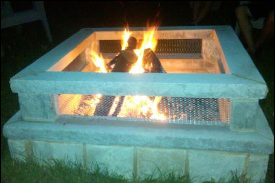Custom square lannon stone fire pit in Dodge County, featuring stainless steel see-through window screens for enhanced fire visibility and warmth distribution.