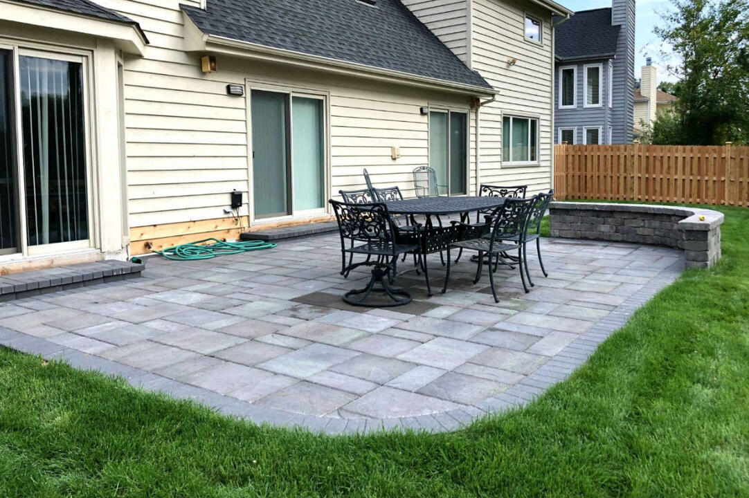 South Milwaukee paver patio with brick stoop, block sitting wall, and Metropolitan Collection Dimensions 3-piece patio system, creating a comfortable outdoor dining and entertainment area.