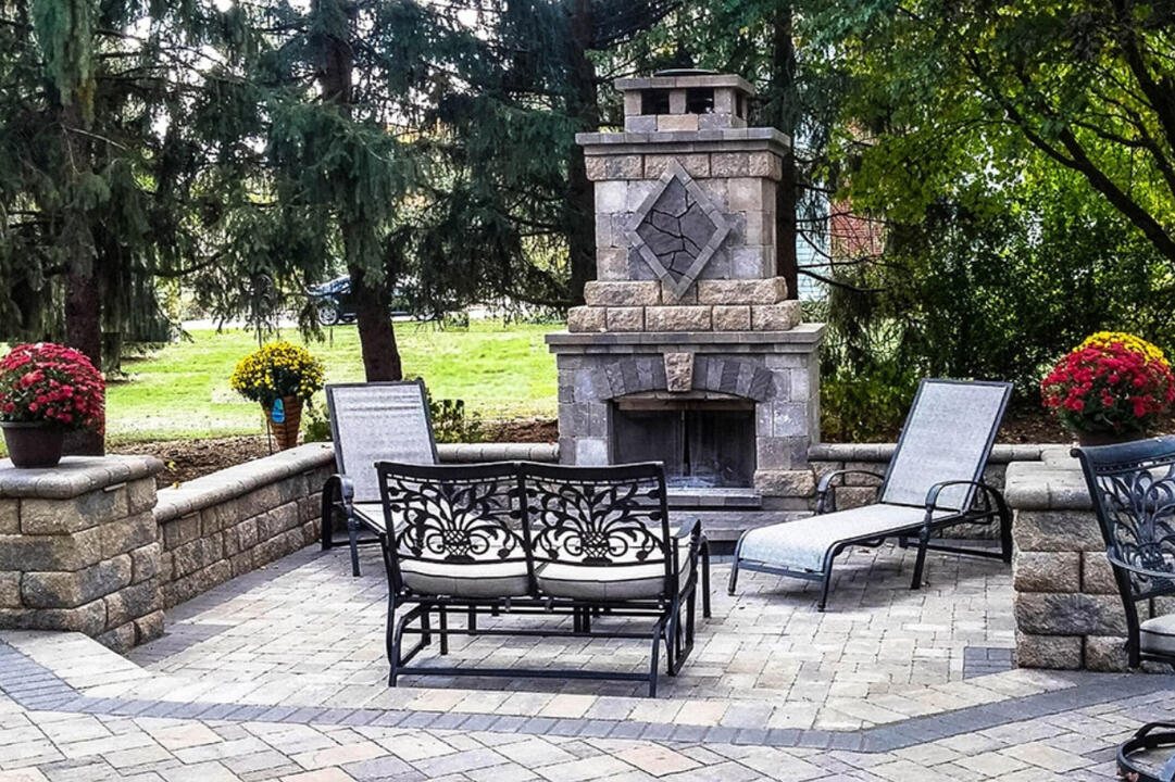 Oconomowoc outdoor living room with Belgard fireplace, custom paver patio, and retaining wall. Durable, weather-resistant materials designed for beauty and functionality.